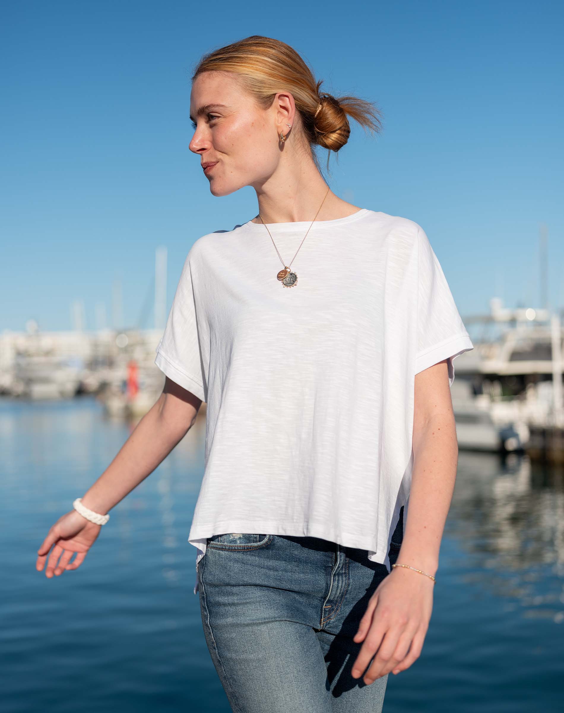 Women's travel-friendly white short-sleeve tee with a relaxed fit and wide neckline in a soft jersey texture.
