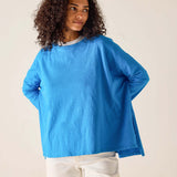 Woman wearing a blue sweater against a beige background