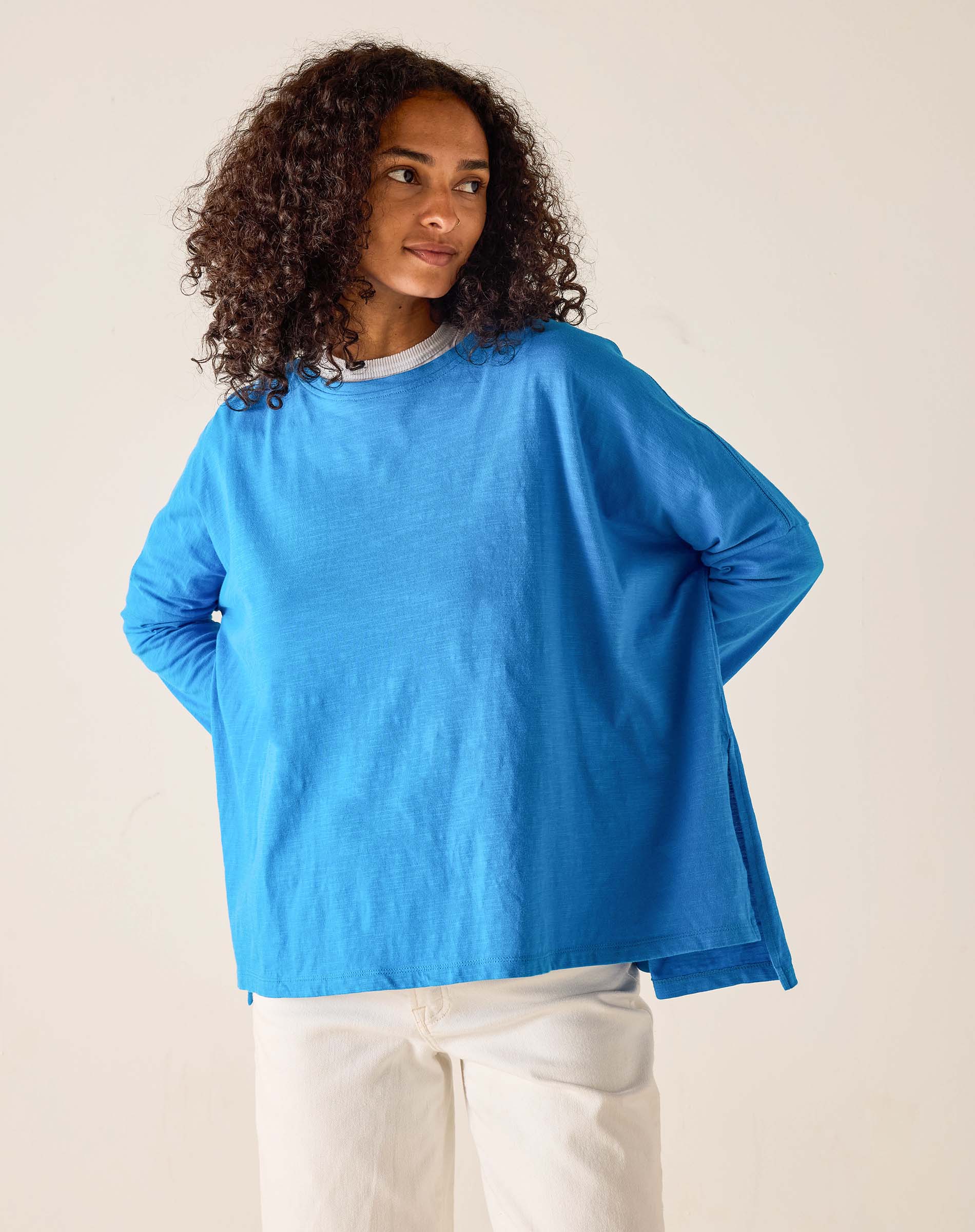 Woman wearing a blue sweater against a beige background