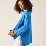 Woman wearing a blue sweater against a beige background