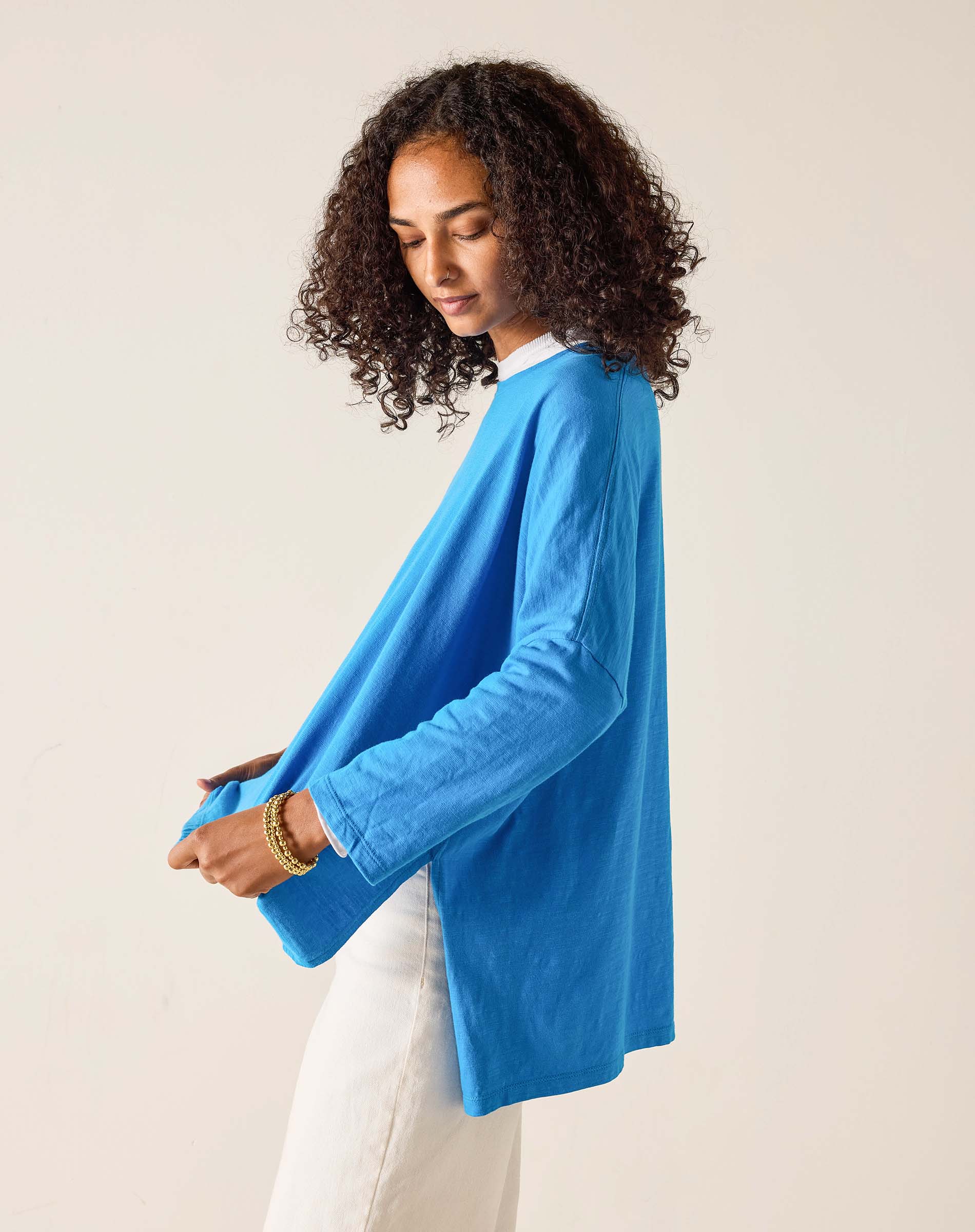 Woman wearing a blue sweater against a beige background