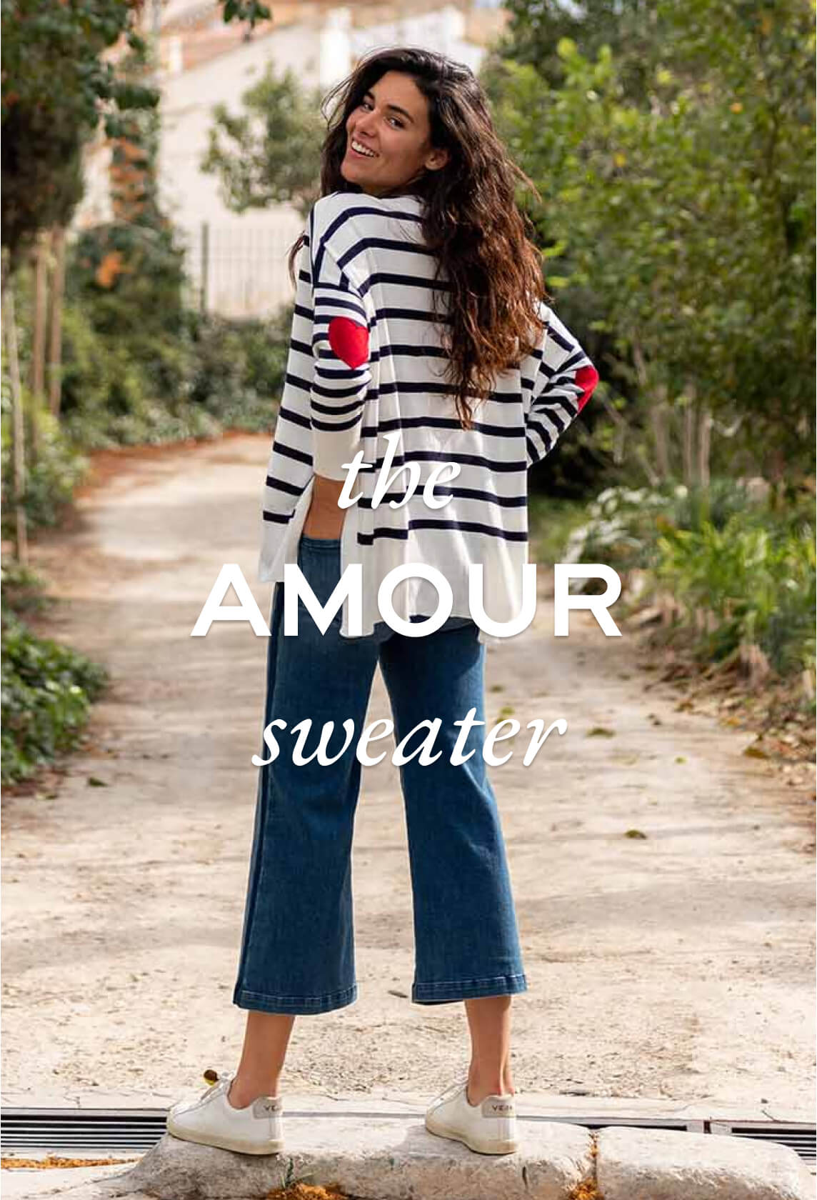 rearview of woman wearing mersea amour sweater in white and navy stripe with red hearts on elbows