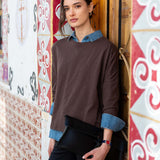 Model wearing the espresso-colored slub knit tee with a layered blue denim collar and dark pants.