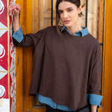 Espresso slub tee with a relaxed fit and long sleeves layered over a denim shirt.