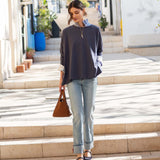 MERSEA women's travel-friendly indigo slub tee with a relaxed fit and long sleeves layered over a striped shirt.
