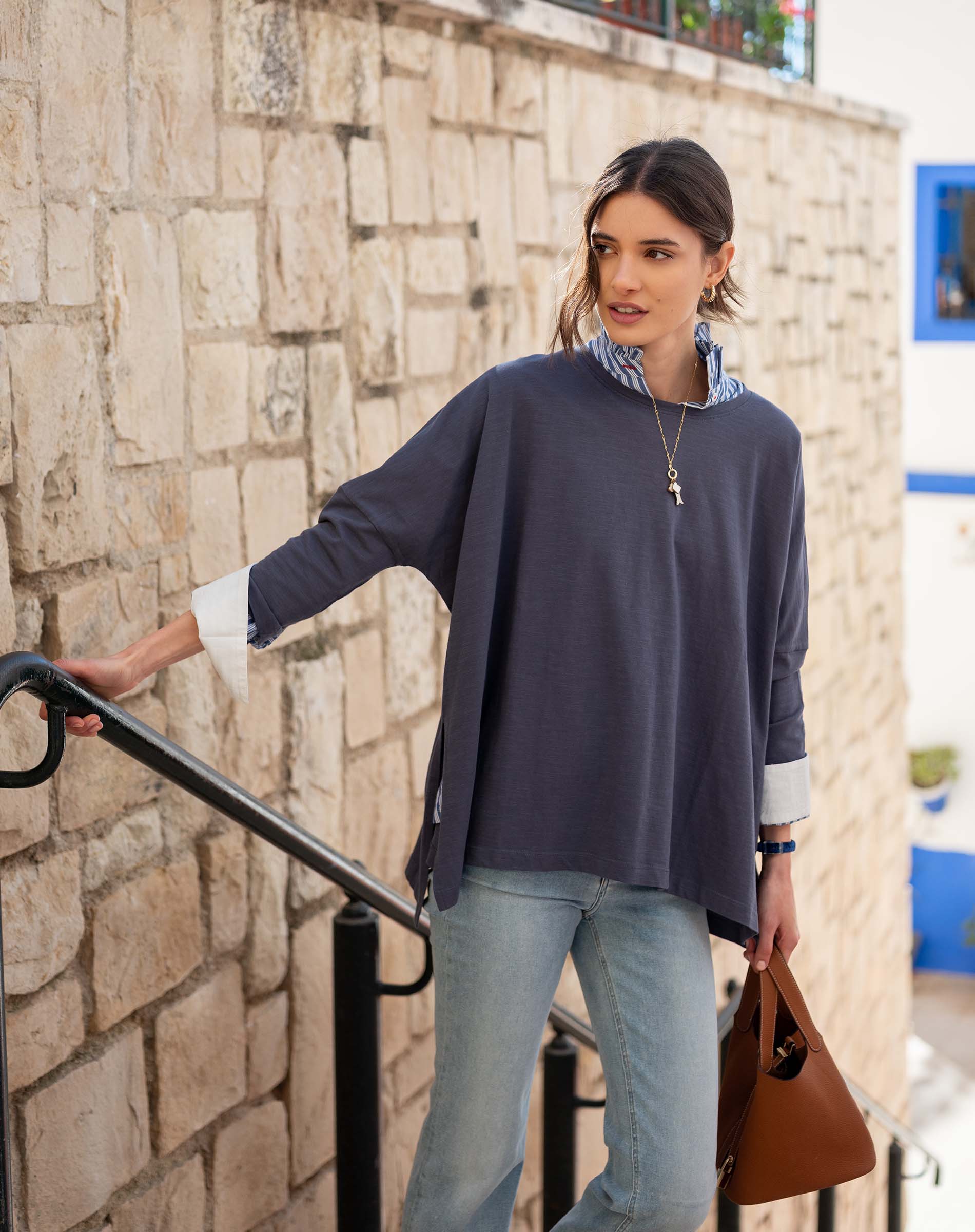 Model in an indigo slub tee with a striped lining and light blue jeans.