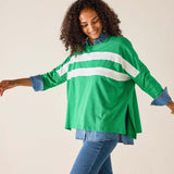 Woman wearing a green and white striped shirt with rolled-up sleeves on a beige background