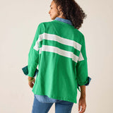 Person wearing a green jacket with white stripes on a beige background