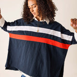 Person wearing a navy jacket with red and white stripes on a plain background
