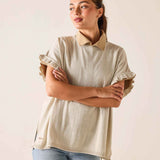 Woman wearing a beige sweater with a collar against a plain background