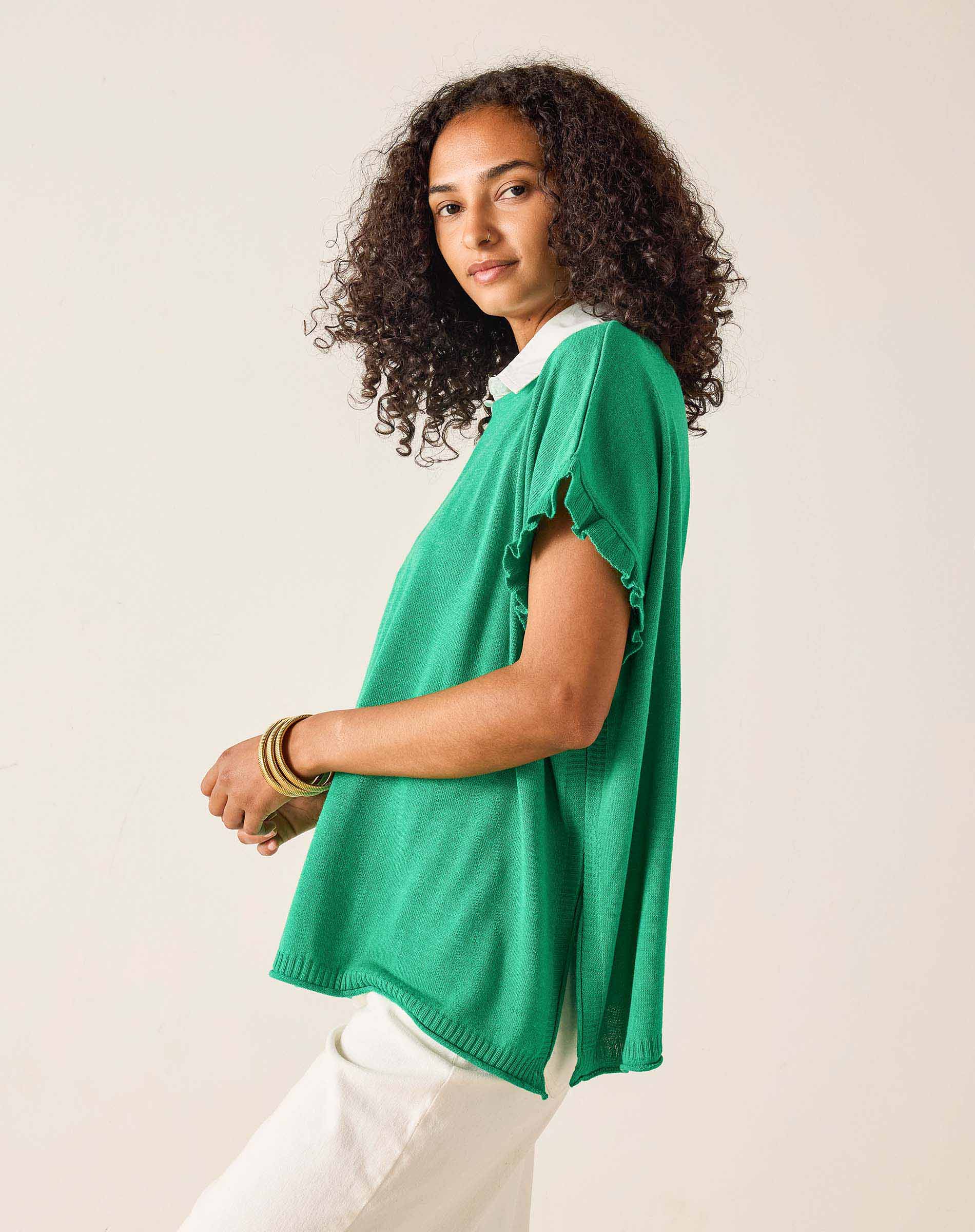Woman wearing a green top with a plain background
