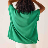 Person wearing a green sweater with a plain background
