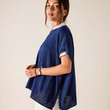 Woman wearing a blue oversized shirt with a plain background