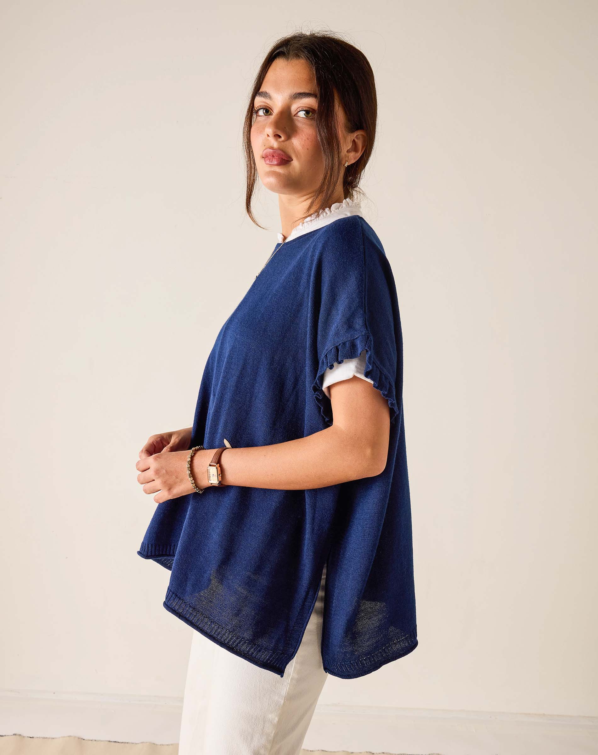 Woman wearing a blue oversized shirt with a plain background