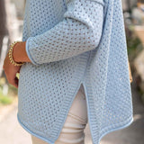 Light blue knitted cardigan worn by a person with a blurred background