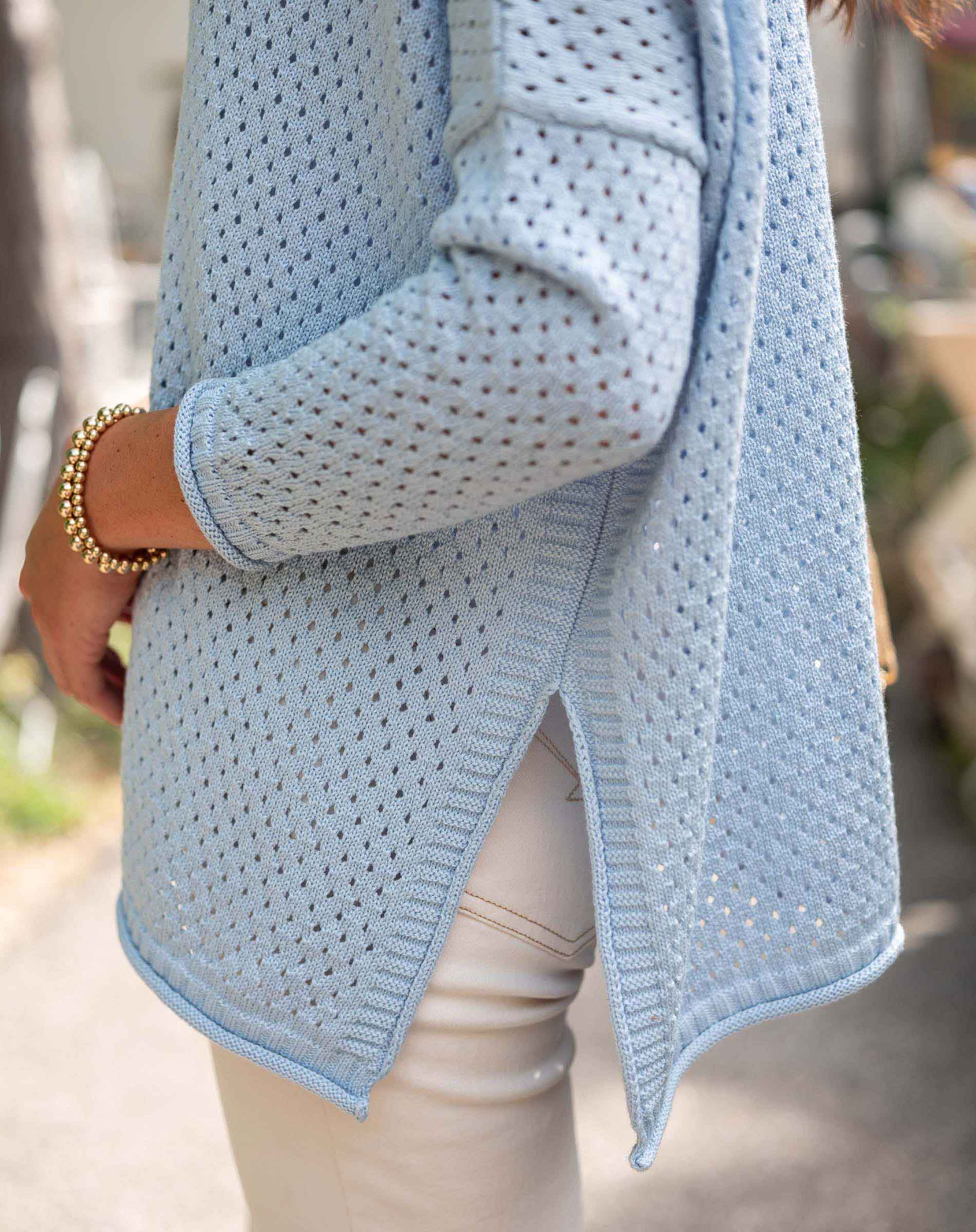 Light blue knitted cardigan worn by a person with a blurred background