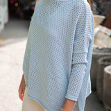 Light blue knitted sweater worn by a person outdoors