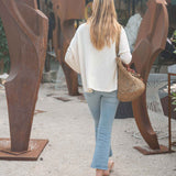 Woman walking past large metal sculptures in an outdoor setting