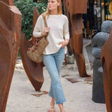 Woman walking outdoors near artistic metal sculptures