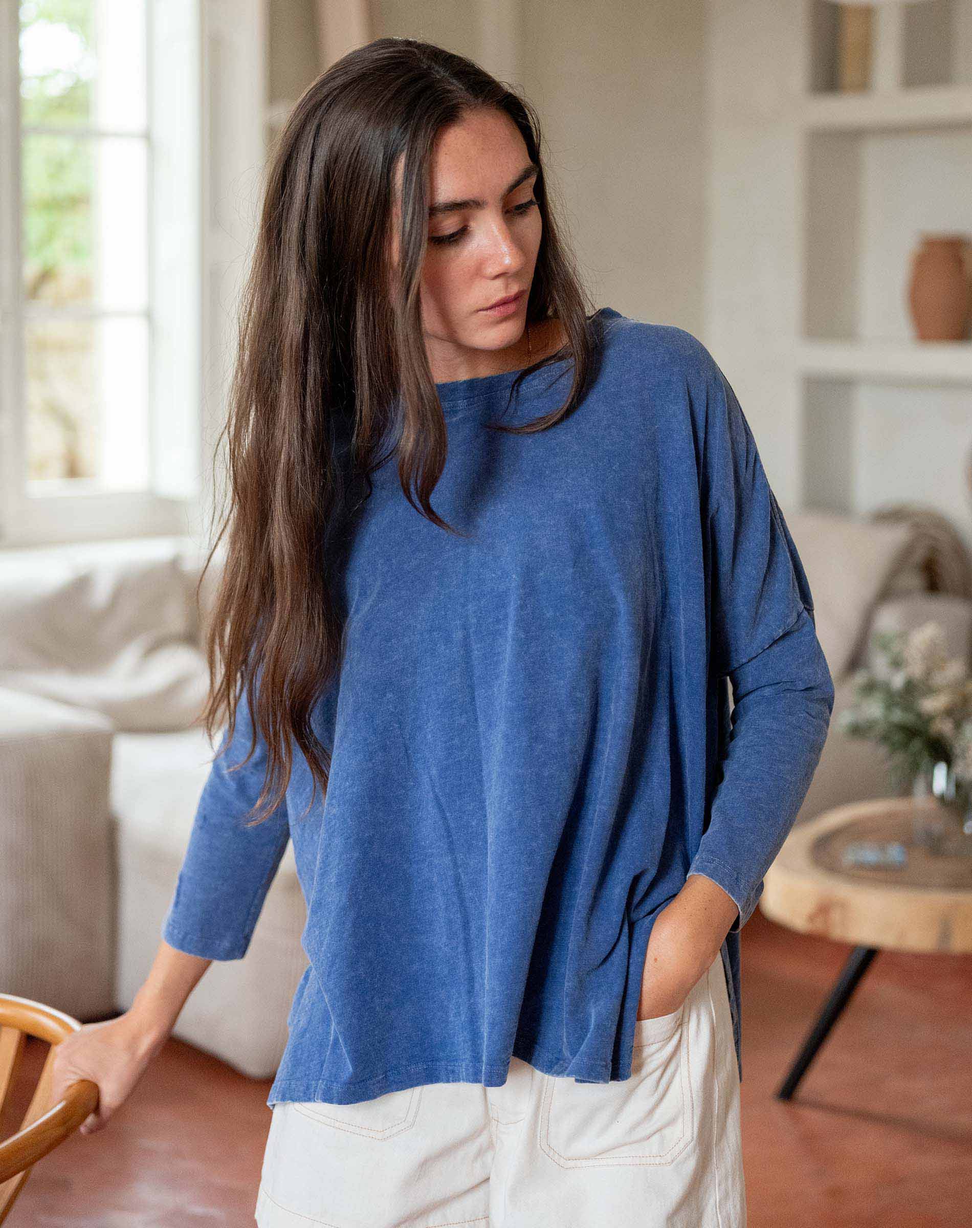 Woman wearing a blue sweater in a living room setting