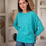 Woman wearing a green top and denim shorts in living room
