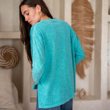 Woman wearing a green top and denim shorts in living room