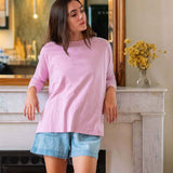Woman wearing a pink top and denim shorts in living room