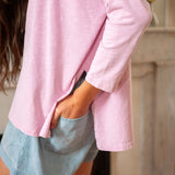 Woman wearing a pink top and denim shorts in living room