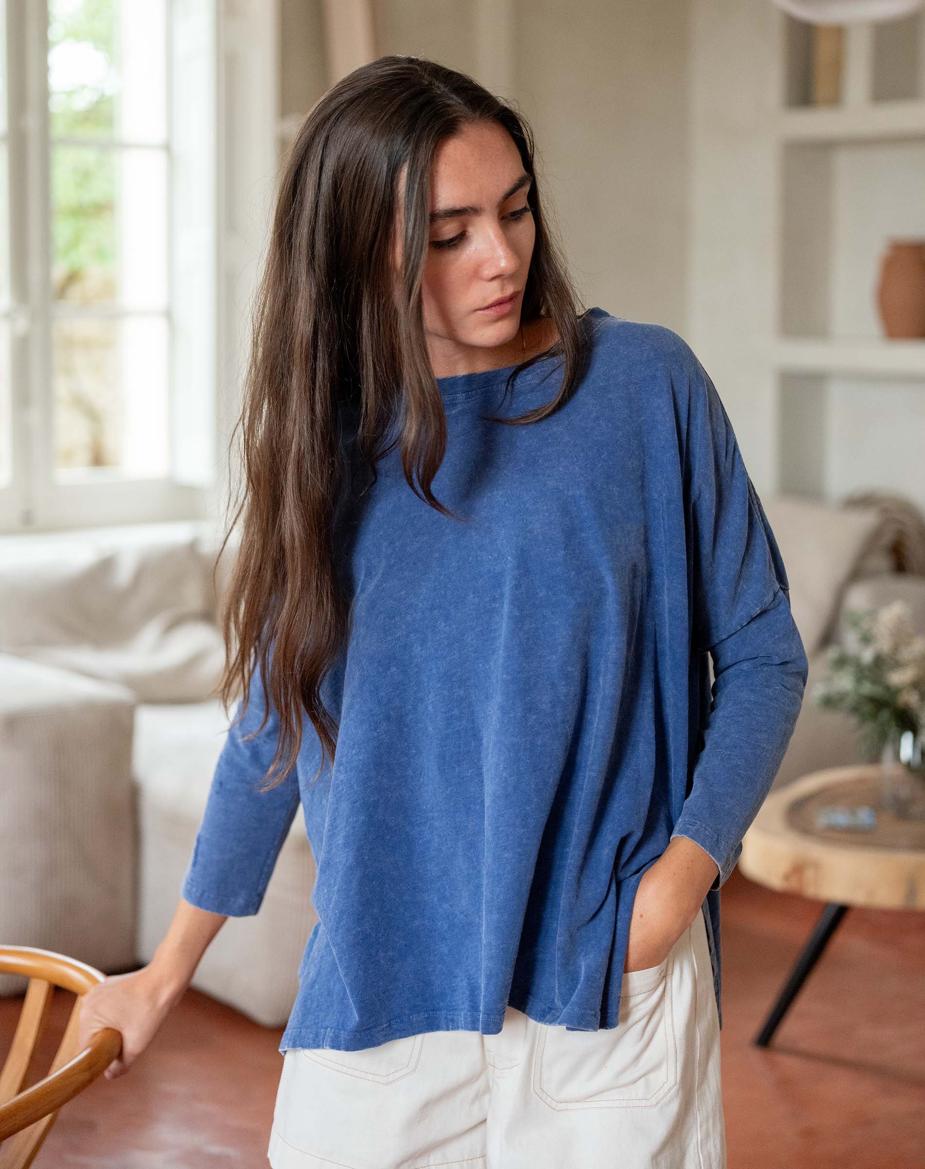 Woman wearing a blue sweater in a living room setting