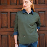Woman wearing a green sweater with a wooden door background