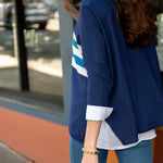 Person wearing a blue jacket with white stripes outdoors