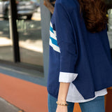 Person wearing a blue jacket with white stripes outdoors