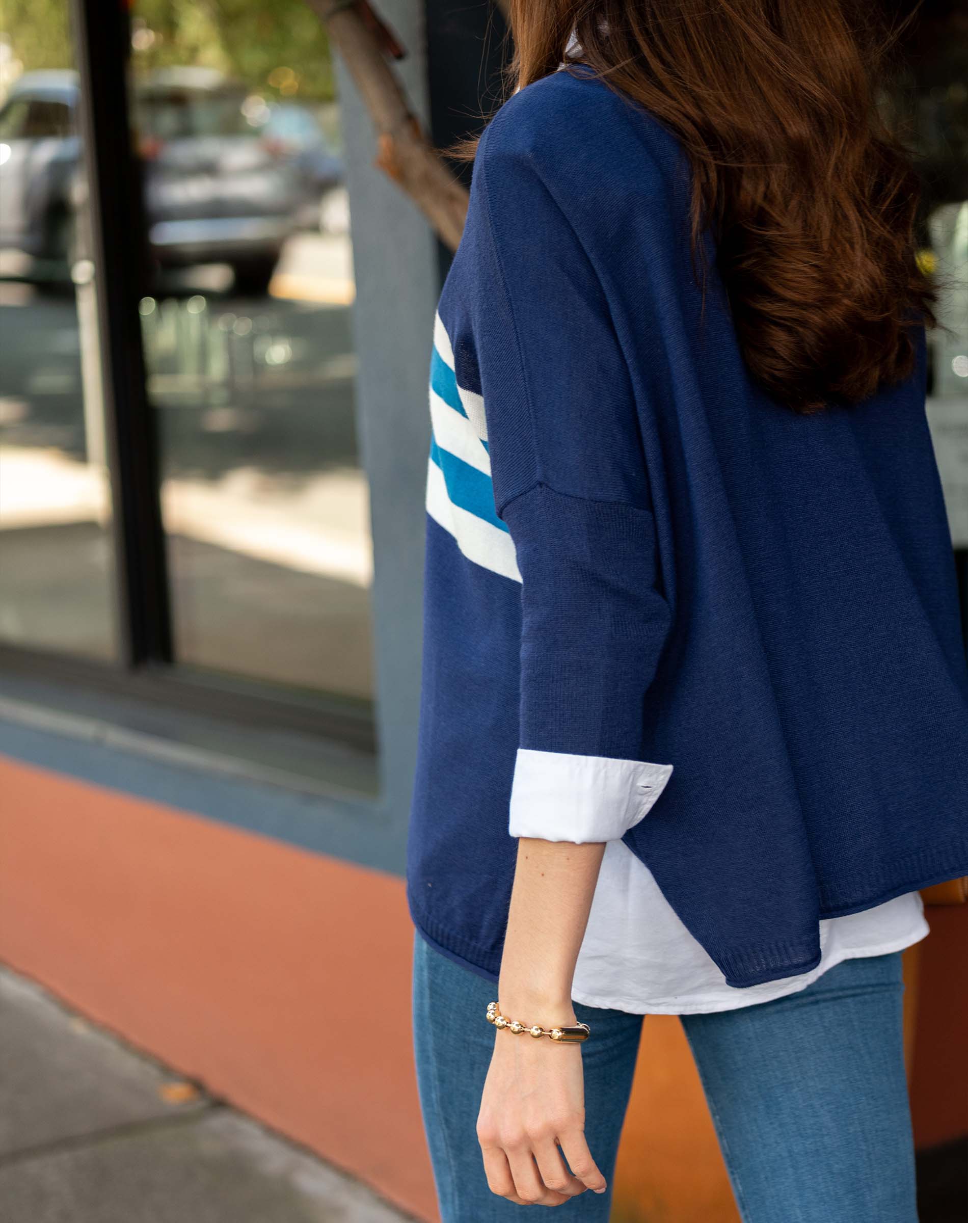 Person wearing a blue jacket with white stripes outdoors