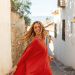 female wearing red sweater with dark jeans spinning in the streets of the country side of spain