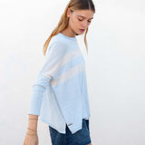 Woman wearing a light blue sweater with a white stripe on a white background