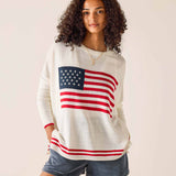 Woman wearing a sweater with an American flag design on a plain background