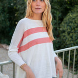 Woman wearing a white sweater with red stripes outdoors