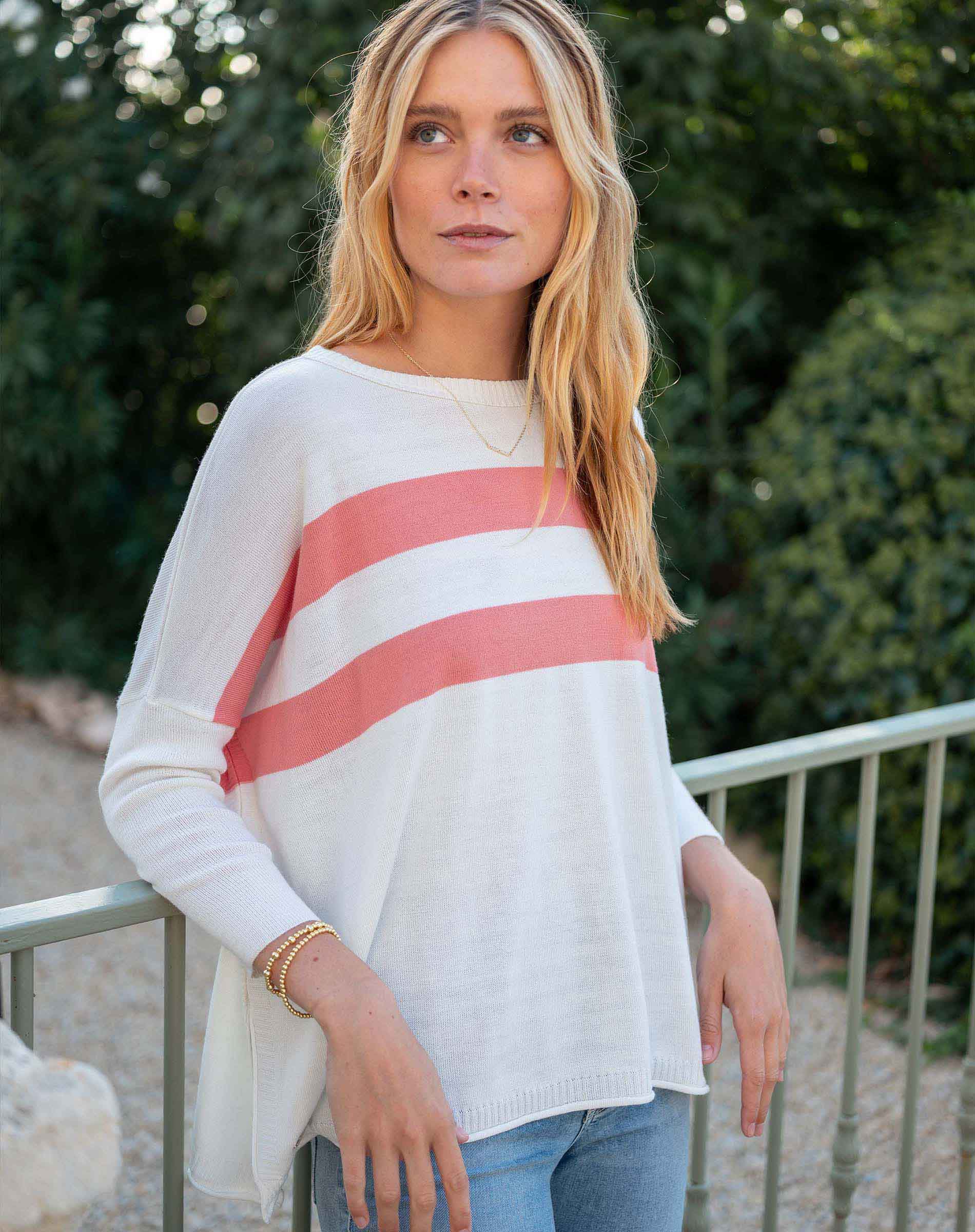 Woman wearing a white sweater with red stripes outdoors