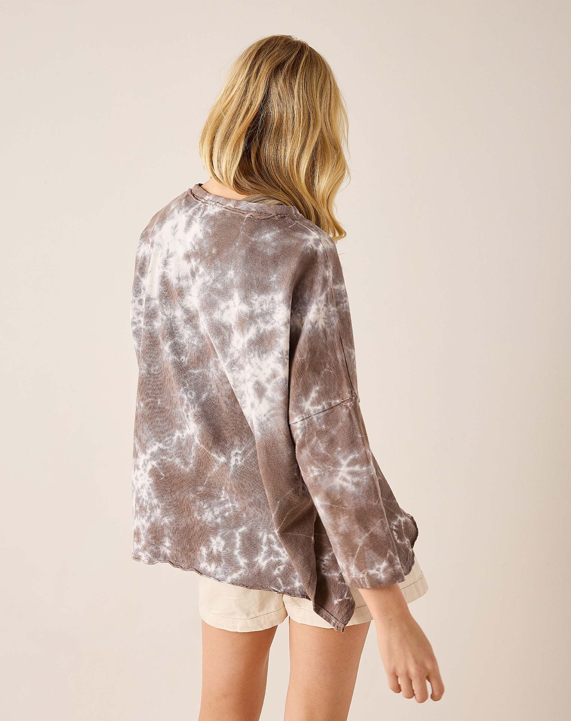 Person wearing a tie-dye shirt with a plain background