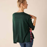 Forest green knit sweater with a tie-side hem detail and striped accent