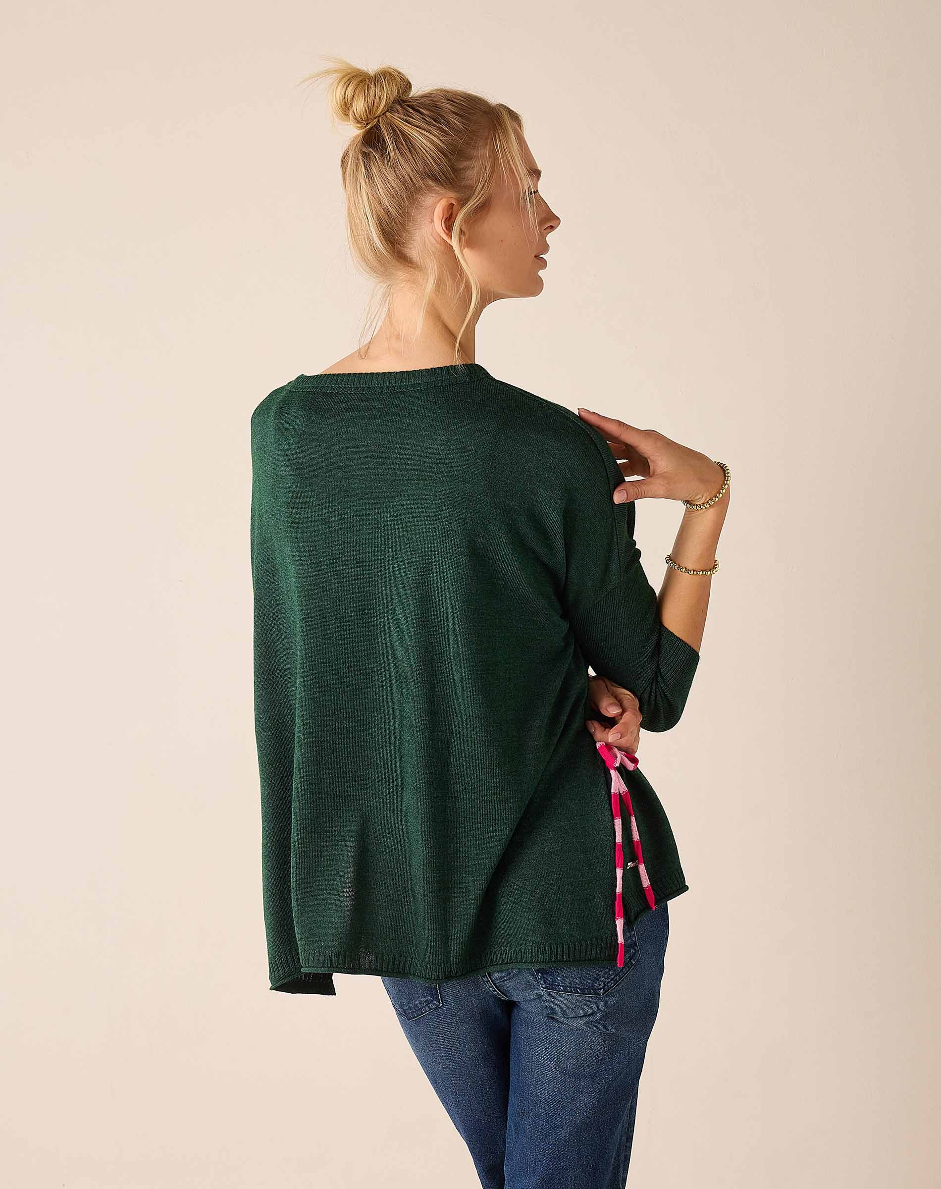 Forest green knit sweater with a tie-side hem detail and striped accent
