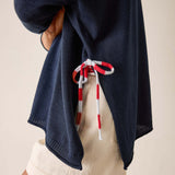 Navy blue hooded garment with red and white drawstrings on a neutral background