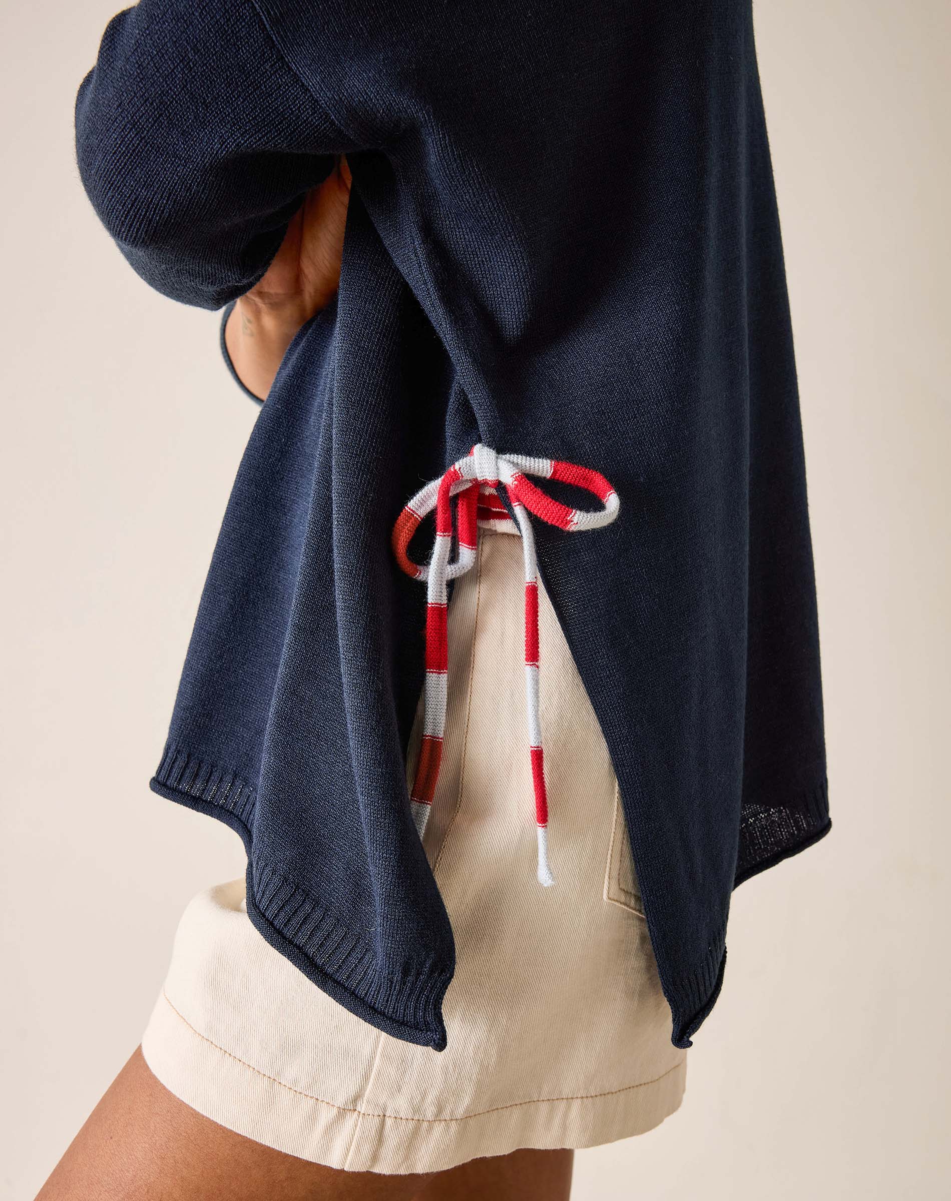 Navy blue hooded garment with red and white drawstrings on a neutral background