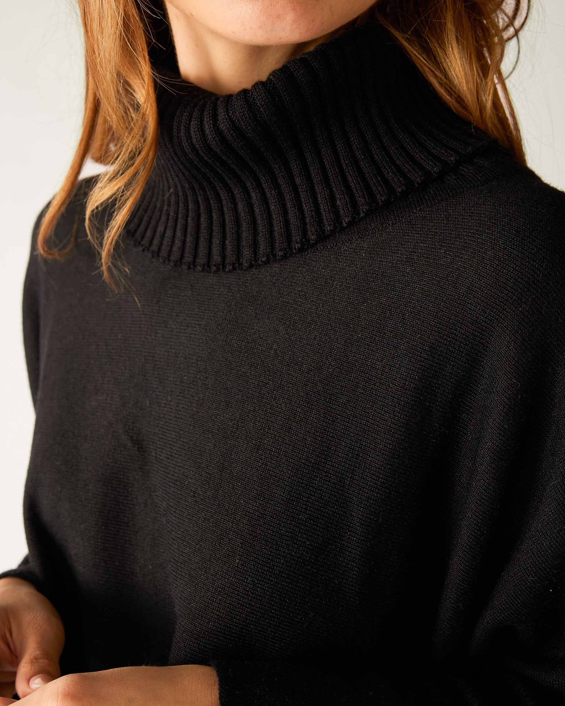 closeup of collar on woman wearing lightweight knit mersea catalina turtleneck sweater in black