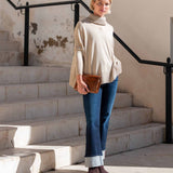 Putty-colored oversized turtleneck knit sweater with voluminous sleeves.