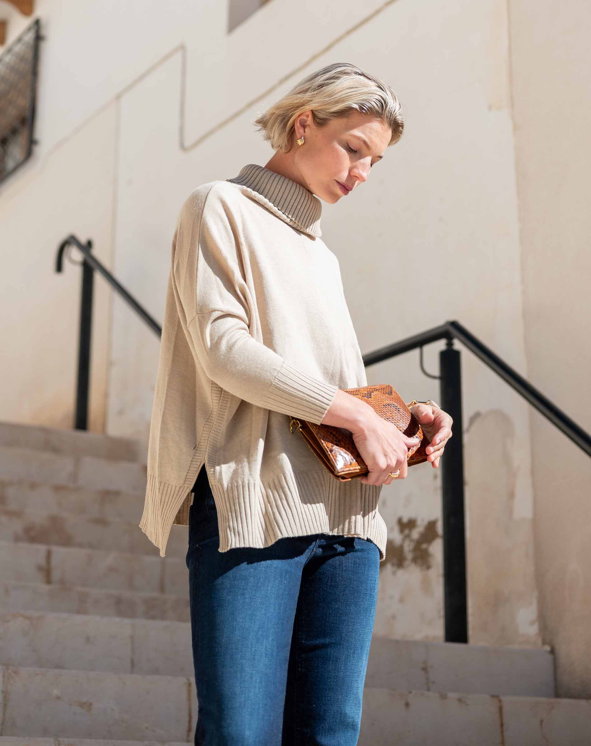 Putty ribbed knit turtleneck sweater with dropped shoulders and long sleeves.