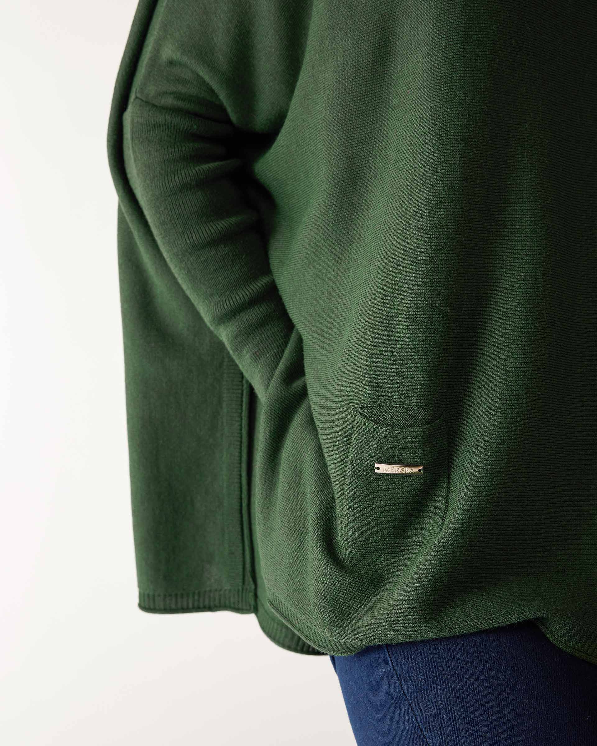 closeup of small front pocket on woman wearing lightweight knit mersea catalina turtleneck sweater in silver pine green