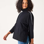 Woman wearing a black jacket with a white stripe on a white background