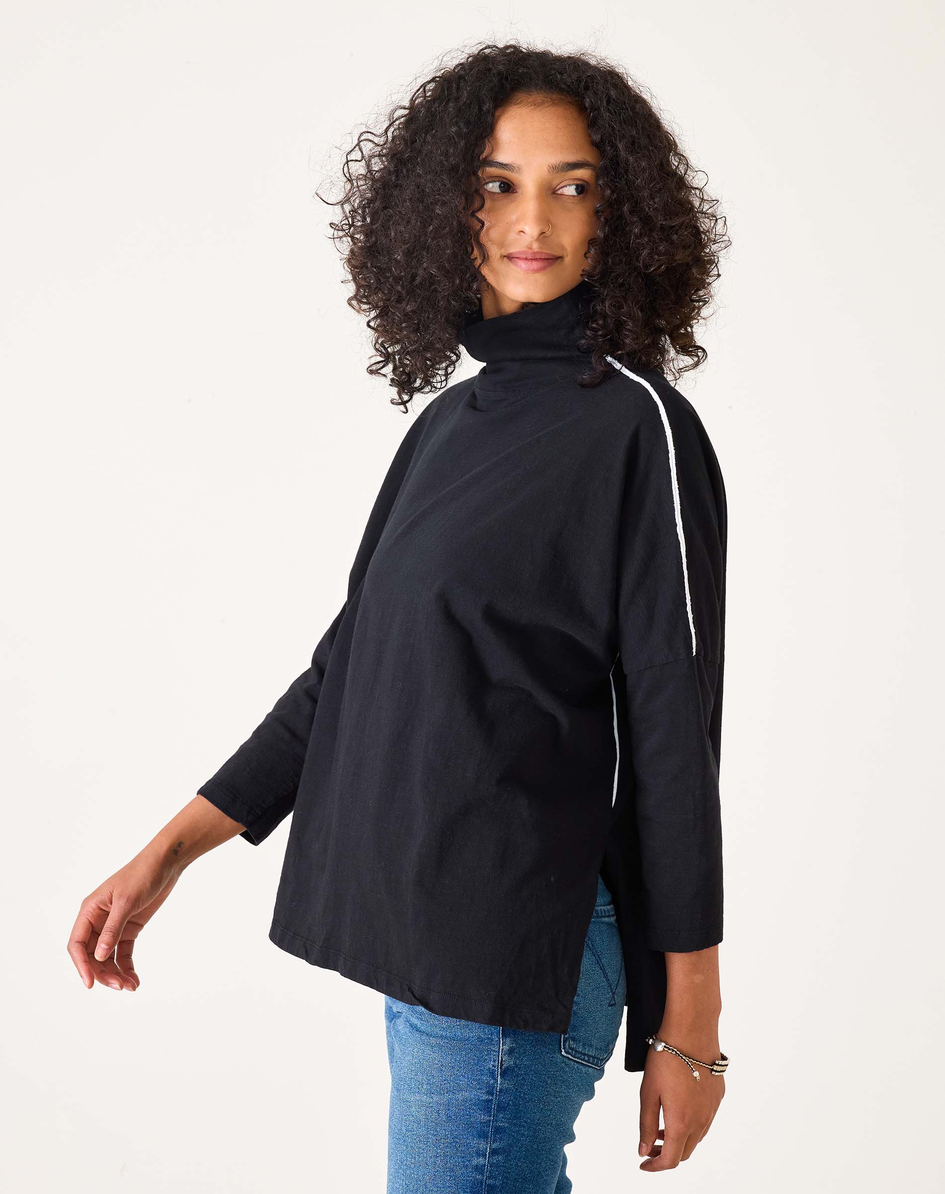 Woman wearing a black jacket with a white stripe on a white background