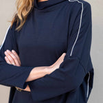 Navy blue long-sleeve top with white accents worn by a person against a neutral background